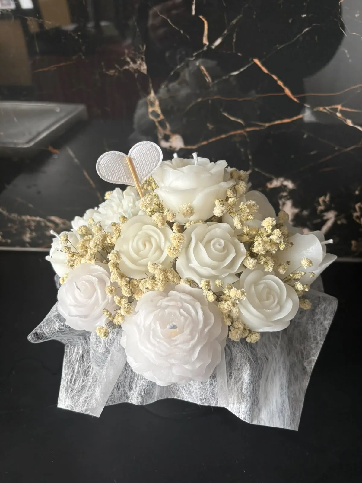 Bouquet de rosas de cera brancas com gipsófila seca e um coração branco no topo, embrulhado em tule branco