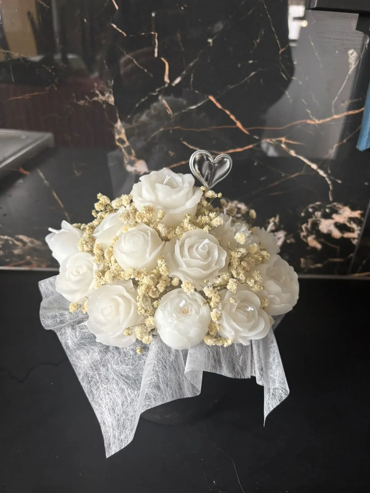 Bouquet de rosas de cera brancas com gipsófila seca e um coração branco no topo, embrulhado em tule branco
