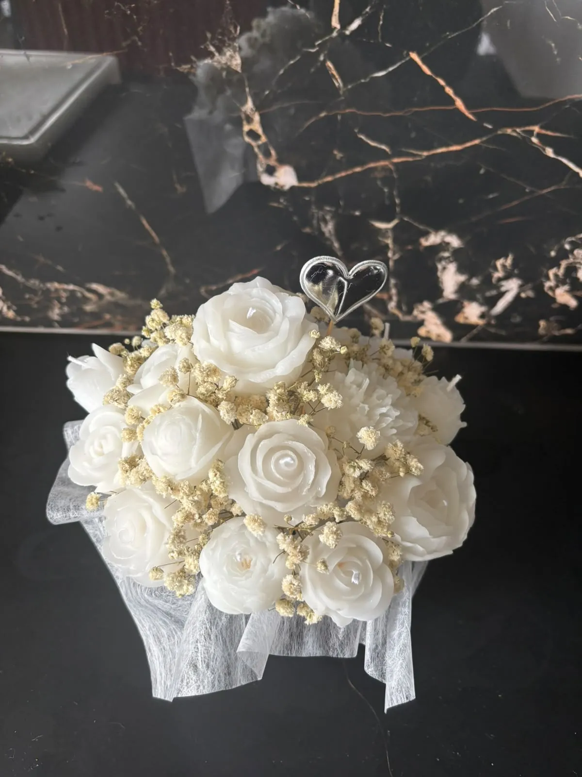 Bouquet de rosas de cera brancas com gipsófila seca e um coração branco no topo, embrulhado em tule branco