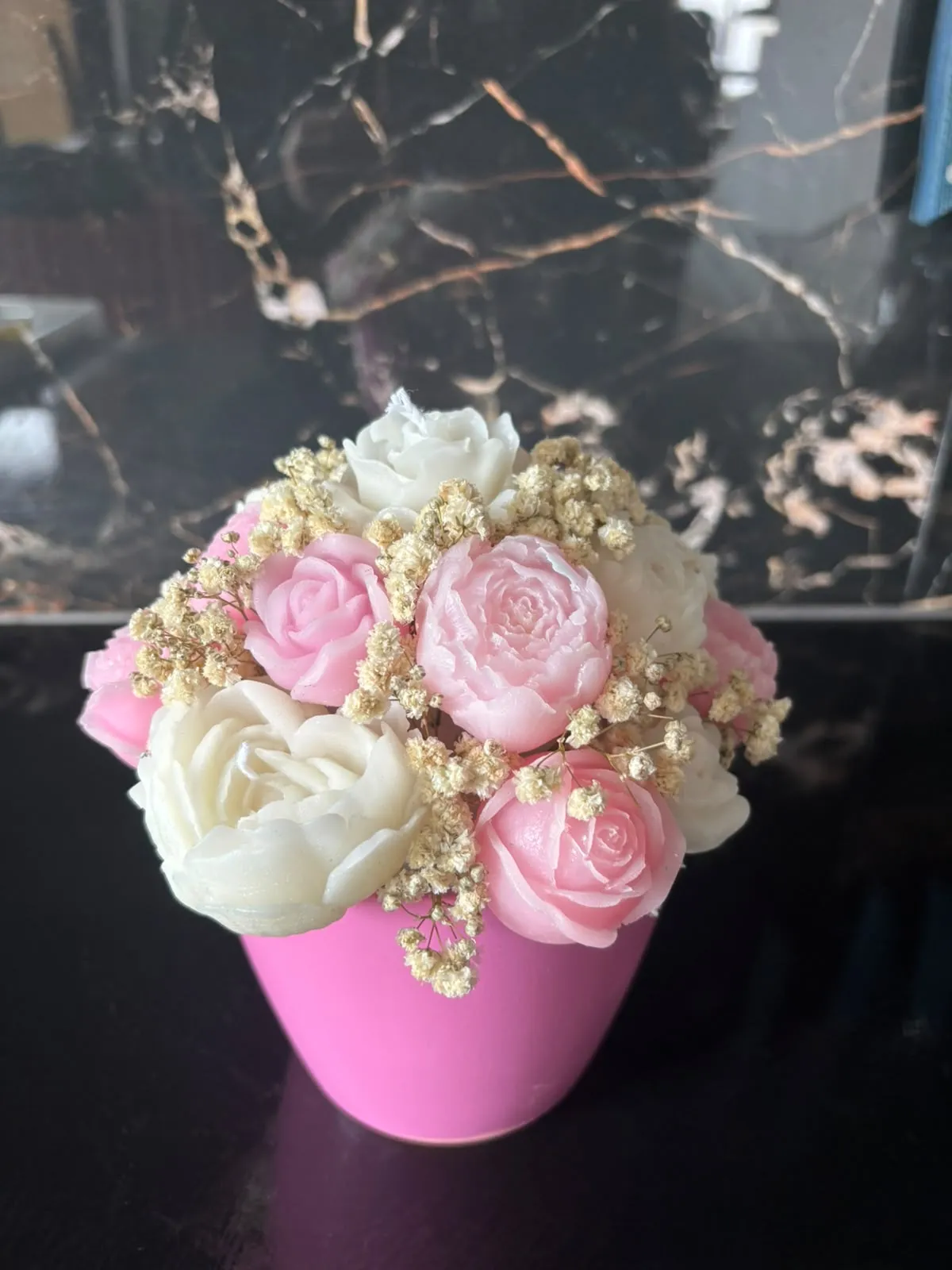 Bouquet de rosas de cera cor-de-rosa e brancas com gipsófila seca, num vaso cor-de-rosa