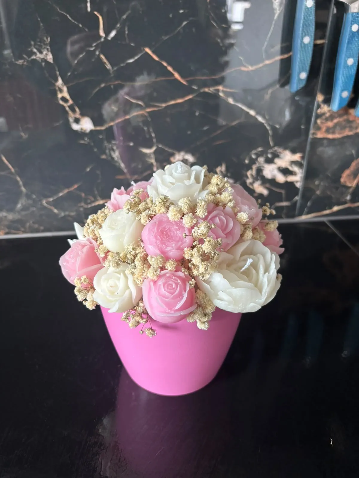 Bouquet de rosas de cera cor-de-rosa e brancas com gipsófila seca, num vaso cor-de-rosa