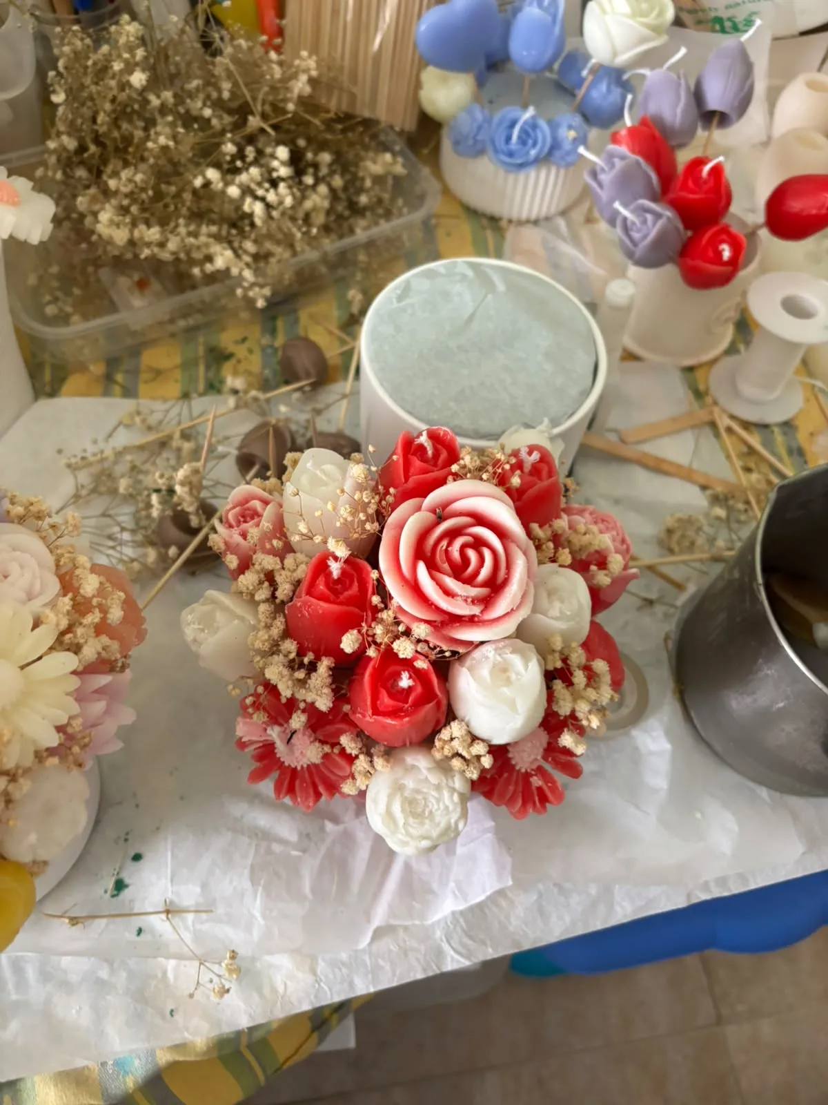 Bouquet de velas com rosas vermelhas, rosa e brancas, na bancada de trabalho