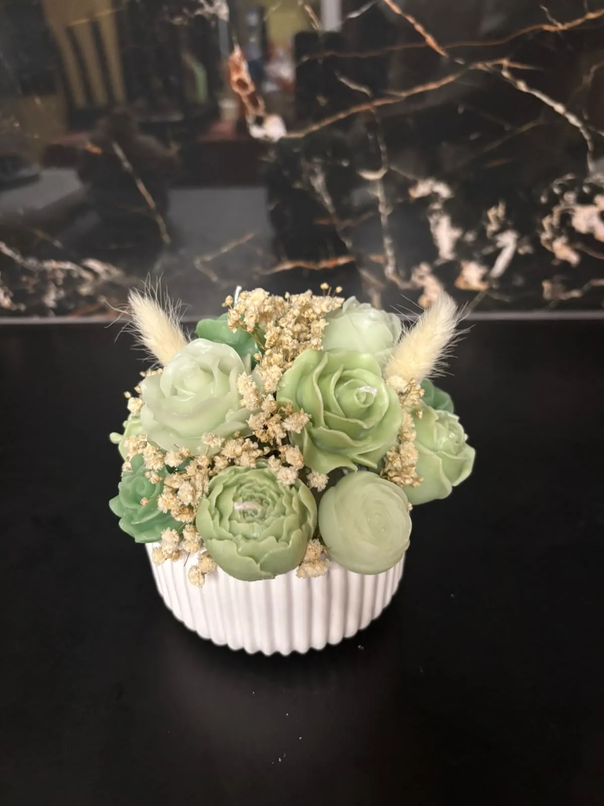Composição artesanal de flores em cera, que combina tons de verde vivo e verde-claro.
