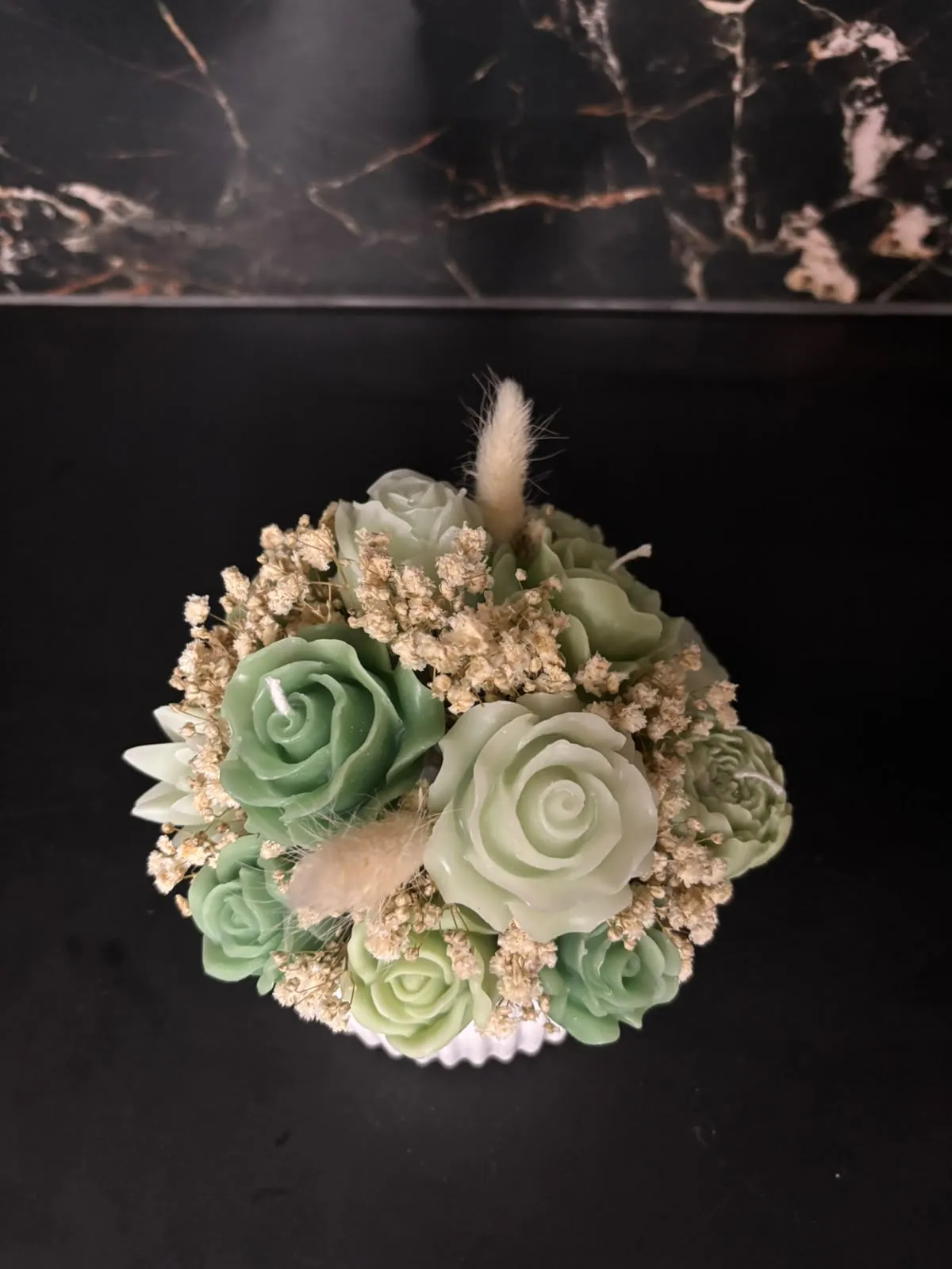 Composição artesanal de flores em cera, que combina tons de verde vivo e verde-claro.