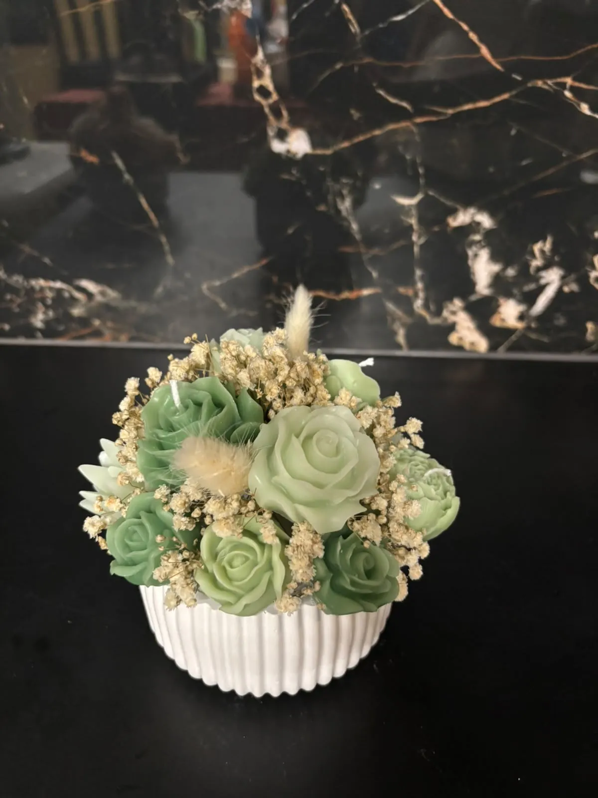 Composição artesanal de flores em cera, que combina tons de verde vivo e verde-claro.