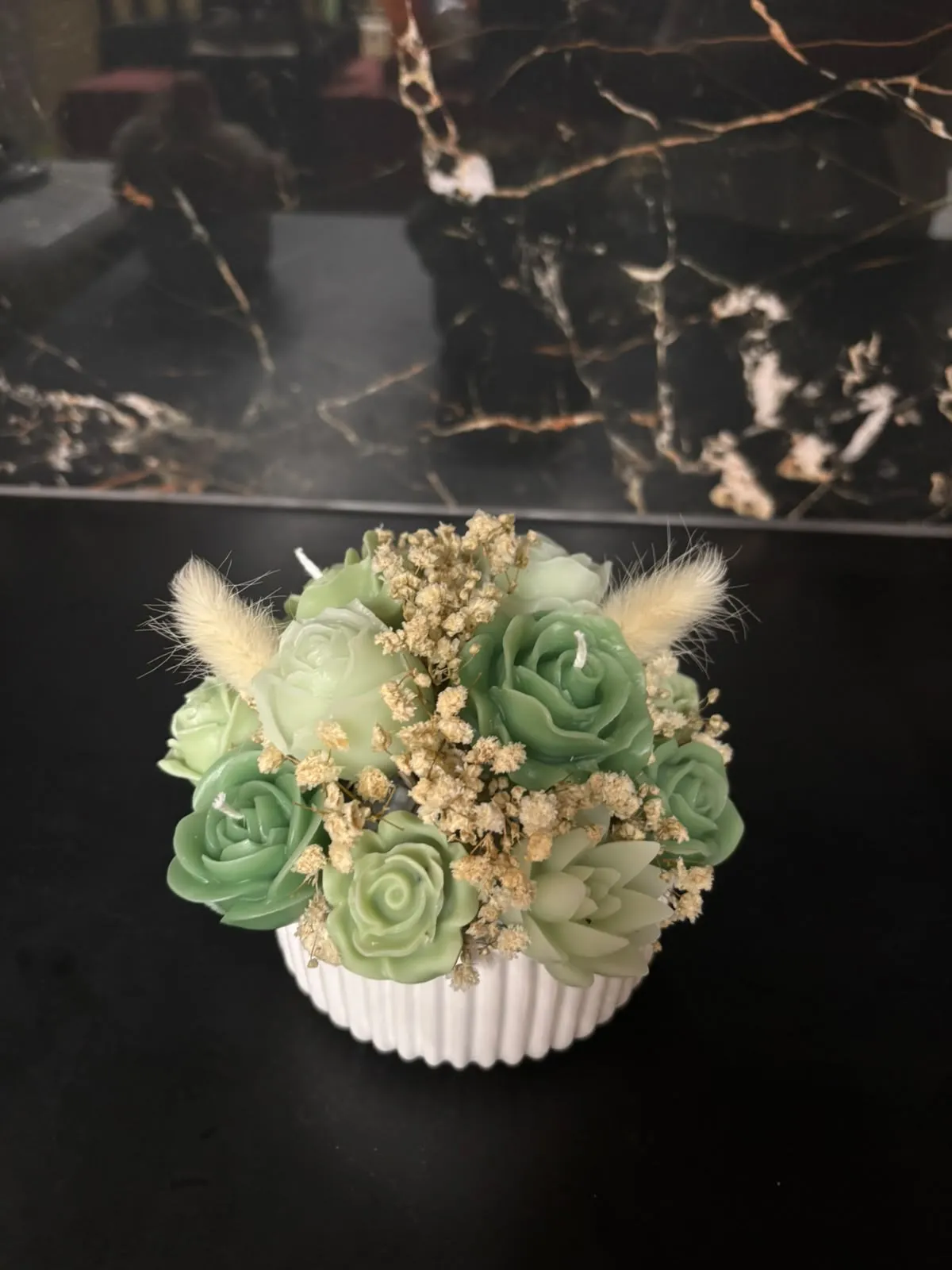 Composição artesanal de flores em cera, que combina tons de verde vivo e verde-claro.